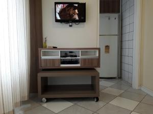 TV en la parte superior de un soporte de TV en una cocina en Ótimo Apto. 180 metros do Mar en Balneário Camboriú