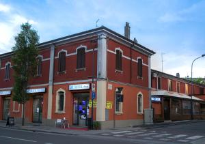 ein rotes Backsteingebäude in einer Stadtstraße in der Unterkunft Cristal Rooms in Piacenza