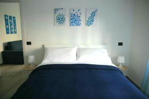 サレルノにあるCasa Mariùのベッドルーム(青と白のベッド1台、ランプ2つ付)