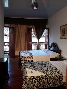 Duas camas num quarto com estampa de leopardo em Bonsai Hotel Salamina Caldas em Salamina