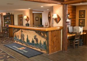 a bar in a lodge with a picture of giraffes at Stoney Creek Hotel Wausau - Rothschild in Rothschild