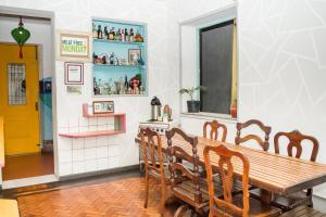 a room with a table, chairs, and a clock on the wall at Mambembe Hostel in Rio de Janeiro