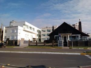 a building on the side of a street next to a road at Pousada Solar Inn in Torres