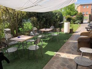 a group of tables and chairs under a white umbrella at Hotel Angi in Fossò