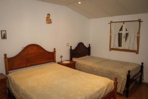 a bedroom with two beds and a window at Adega Do Martinho in Milhão