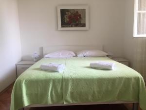 a bedroom with a green bed with two pillows on it at Apartment Dubcic: For perfect vacation in Dubrovnik