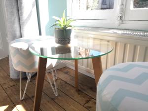 a glass table with a potted plant on top of it at maison courbarien in Saint-Georges-la-Pouge