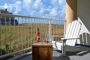 een fles alcohol op een tafel op een veranda bij Beach House SEA-side in Egmond aan Zee