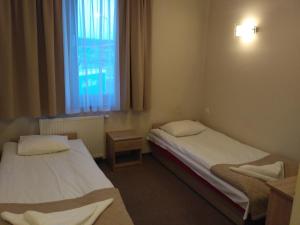 2 Betten in einem Zimmer mit Fenster in der Unterkunft Hotel Nowostawy A2 MOP in Nowostawy Dolne