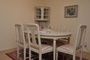 einen Esstisch mit 4 Stühlen und einen Tisch mit einem Glas in der Unterkunft Lenas Bed & Breakfast in Degerfors