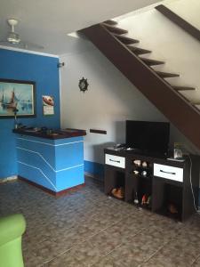 sala de estar con TV y pared azul en Pousada Azul do Mar, en Arraial do Cabo