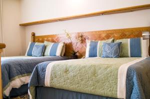 a bedroom with two beds with blue pillows at Cancun Beachfront Condo in Cancún +26 photos