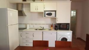 ベラにあるnaturist apartamentのキッチン(白いキャビネット、洗濯機、乾燥機付)