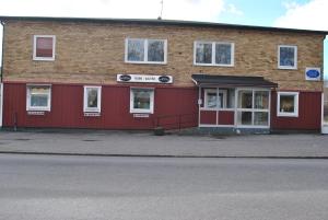 ein rotes Gebäude mit weißen Fenstern auf einer Straße in der Unterkunft Lenas Bed & Breakfast in Degerfors