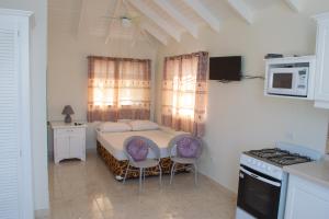a small kitchen with a table and two chairs at Plover Court Apartments in Christ Church +19 photos
