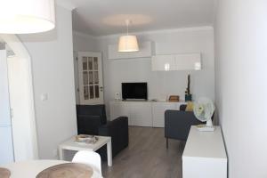 uma sala de estar branca com um sofá e uma mesa em Vigia's Guest House em Viseu