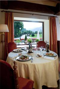 a table with plates of food and wine glasses at Parador de Fuente Dé in Fuente Dé