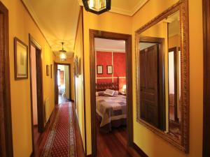 pasillo con habitación con cama y espejo en Hostería Miguel Angel, en Santillana del Mar