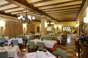 a dining room with white tables and green chairs at Parador de Fuente Dé in Fuente Dé