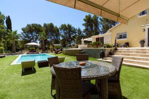 a backyard with a table and chairs and a pool at VILLA LA CIOTAT CASSIS Calanques in La Ciotat