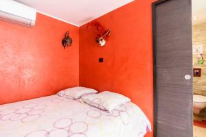 ラ・シオタにあるVILLA LA CIOTAT CASSIS Calanquesのオレンジ色の壁のドミトリールームのベッド1台分です。