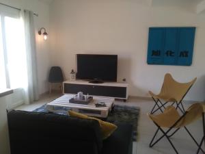 a living room with a couch and a tv and chairs at Les Malvas in Romorantin