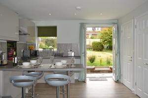 uma cozinha com uma mesa e bancos num quarto em Little Dene Apartment em Salisbury