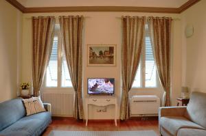a living room with a blue couch and a tv at Luxury Fiesolana apartment in Florence