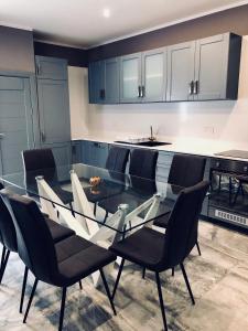 a kitchen with a glass table and black chairs at Holiday townhouse in Sliema centre in Sliema