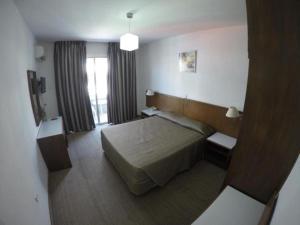 a hotel room with a bed and a window at Les Palmiers Petrou Apartments in Larnaca