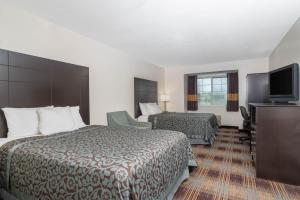 a hotel room with two beds and a flat screen tv at Days Inn by Wyndham Faribault in Faribault
