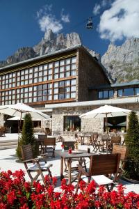 un hotel con mesas y sombrillas frente a un edificio en Parador de Fuente Dé, en Fuente Dé