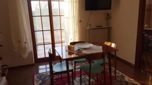 a dining room with a table and chairs and a window at La Stanza Di Alice in Ponzano di Fermo