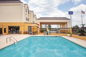 a swimming pool with a pool table and chairs at Baymont by Wyndham Saraland in Saraland