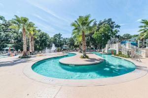 a pool with a fountain in a park with palm trees at Coral Sands Resort by Palmera in Hilton Head Island