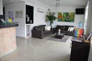 una sala de estar con un sofá y una mesa en Hotel Santa Cecilia Cali, en Cali