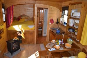 Una habitación con una cama y una estufa en una cabaña en La Maison de l'Omignon en Vermand