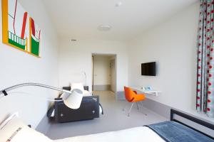 a bedroom with a bed and a desk and a chair at Hotel Middelpunt - Gratis Parking - Ontbijt inbegrepen - in Middelkerke
