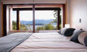 Tempat tidur dalam kamar di BOG Atardeceres del lago - piscina climatizada y vistas al lago