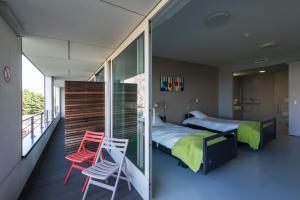 a bedroom with a bed and two chairs on a balcony at Hotel Middelpunt - Gratis Parking - Ontbijt inbegrepen - in Middelkerke