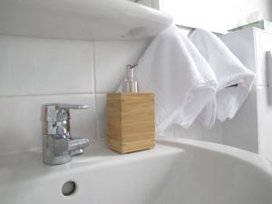 a bathroom sink with a soap dispenser on it at Hygge Apartments Bonn in Bonn