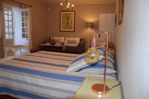 a bedroom with a bed with a lamp on a table at Moulin des Gypses Gîte Les Pierres Blanches, Ventoux in Mormoiron +21 photos