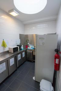 een keuken met een koelkast in het midden van een kamer bij Change The World Hostels - Açores - Ponta Delgada in Ponta Delgada