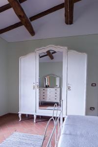 1 dormitorio con espejo y 1 cama en una habitación en Podere Villa Rosa en Torrita di Siena