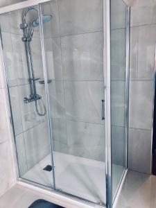 eine Dusche mit Glastür im Bad in der Unterkunft Holiday townhouse in Sliema centre in Sliema