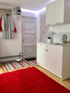 a kitchen with white cabinets and a red rug at 42 Juhkentali in Tallinn