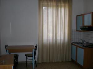 a kitchen with a table and a sink and a curtain at Residence Ducale in Rodi Garganico