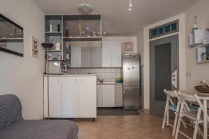 a kitchen with a refrigerator and a table with chairs at Apartment Dina in Medulin