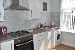 a kitchen with a stove top oven next to a sink at Adelaide Apartments 2 in Blackpool