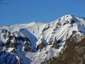 una montagna coperta di neve con un cielo blu di Aux 500 Diables Eco Lodge - Hotel a Chambon-sur-Lac